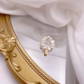 Detail of freshwater pearl ring with a gold letter B pendant on a vintage mirror - Letter B