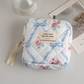 Detailed top view of a quilted floral makeup bag with pink roses and blue bows - Blue Rose with Label and Ribbon