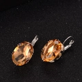 Detailed view of silver hook earrings with large oval amber-colored faceted gemstones - Champagne (Oval)