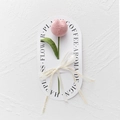 Close-up of pink handmade crochet tulip on white gift card with decorative ribbon - Bulb Tulip - Light Pink