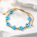 Détail de la perle Mauvais Œil et perles dorées sur le bracelet tressé ajustable - Bleu Ciel