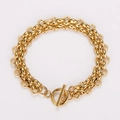 Dettaglio di un bracciale a doppia catena dorata minimalista con chiusura a levetta OT industriale - Oro