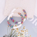 Detail of bohemian round hoop earrings featuring colorful rainbow polymer clay clay discs - Spotted Multi-color