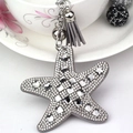Close-up of a grey starfish keychain featuring sparkling rhinestones and a matching tassel - Gray
