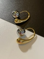 Détail de boucles d'oreilles bicolores avec sphère argentée et gouttes dorées lisses - Style Argent