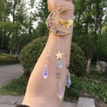 Detail of golden moon suncatcher with colorful crystals and hanging prism pendants - Fluorite