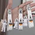 Three white and grey astronaut keychains with rocket straps held by hand display - No.2 Silver 3-Piece Keychain Set (White Strap)