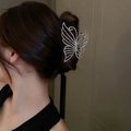 Elegant silver butterfly metal hair claw clip with cutout design shown on model's hair - Hollow Butterfly Shape / Medium / Silver