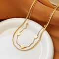 Collana a doppio strato dorata con ciondoli a cuore su un piatto in ceramica bianca - Collana A Doppio Strato Con Cuore / Oro