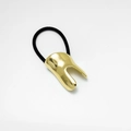 Detail of a minimalist gold U-shaped alloy ponytail cuff with a sturdy black elastic band - Gold