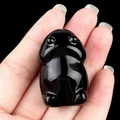 Polished natural black stone frog figurine carving held by hand for desktop decor - Obsidian