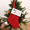 Red knit Christmas stocking with embroidered letter J and holly leaf on white cuff - Letter J