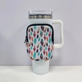 Close-up of neoprene 40oz tumbler pouch with colorful feather pattern on a white mug - No. 6 Feather