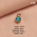 Rose gold round birthstone pendant with teal faceted crystal on pink silk fabric - Lake Blue