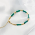 Detail of beaded malachite bracelet with gold beads and lobster clasp on white silk - 17+5cm / Malachite-Gold
