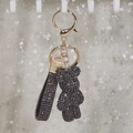 Detailed view of dark grey rhinestone bear keychain with gold metal clasp and strap - Gray
