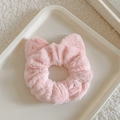 Detail of pink faux fur scrunchie with cute cat ears on a soft textured background - Pink