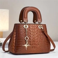 Close-up of brown crocodile texture handbag with gold hardware and star charm detail - Khaki/Earth Yellow