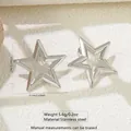 Detailed view of 3.1cm silver star-shaped stainless steel stud earrings with size labels - Hollow Star