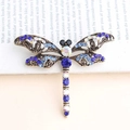 Vintage bronze dragonfly brooch with blue crystal rhinestones on a book background - Dark Blue
