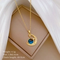 Dettaglio della collana con ciondolo luna e stella dorata con gemma blu su portagioie - Stile Galassia Luna e Stella (C203)