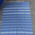 Blue and white striped Turkish beach towel with hand-knotted tassels on terrazzo floor - Sapphire Blue