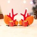 Dettaglio di fermagli natalizi con corna di renna, foglie di peluche e piccoli regali - Stile sacchetto regalo