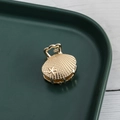Detailed macro shot of golden shell-shaped mini hair claw clip with star engraving - Shell Starfish / Gold