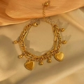 Pulsera de doble capa dorada con corazones y cuentas sobre fondo de seda suave - Pulsera de Corazón de Cuentas de Doble Capa / Dorado