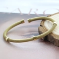Golden woven mesh bangle with five cylindrical metal spacers in a minimalist style - Gold