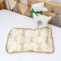 Dettaglio di un cuscino in cotone per neonati con stampa a coniglio e scanalatura centrale - Coniglio di Peluche