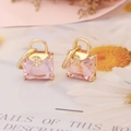 Macro detail of gold handbag earrings with pink square crystal and micro moon accent - Pink