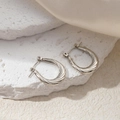 Detail view of silver twisted rope U-shaped earrings on stone and silk background - Twisted Texture U-Shape Earrings (0218)