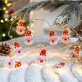 Santa Claus LED string lights with warm yellow glow hanging on snowy pine branches - Santa Head