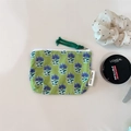 Macro view of green floral cotton coin purse featuring zipper detail and logo tag - The Wizard of Oz Green