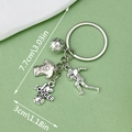 Silver metal soccer keychain with jersey and football charms on green background - Soccer Jersey Athlete