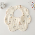 Close-up of petal-shaped cotton gauze baby bib with cartoon animal prints and snap button - Gauze Flower Wrap - Space Animals