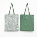 Detail of leaf print and forest green canvas tote bags with Life With Leaves label - White Base Large Leaf