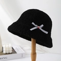 Detail of black faux shearling bucket hat with striped bow and metal emblem - Black