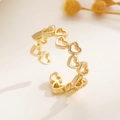 Makro-Detail eines verstellbaren goldfarbenen Rings mit verbundenen hohlen Herzmotiven - Gold Hohles Herz (Ring)