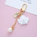 Baroque cupid angel keychain with pearl and heart charms on a pink aesthetic background - Double-Handed Angel with Tag