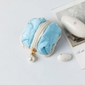 Détail macro d'un étui pour écouteurs bleu clair matelassé avec pendentif en perle - Bleu ciel