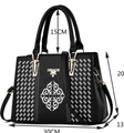 Detailed view of black faux leather tote with floral embroidery and size specifications - White
