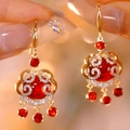 Elegante Chinese gouden oorbellen met rode stenen en glanzende witte zirkonia stenen - Gouden Rode Ruyi Slot Druppel