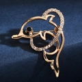 Macro detail of a gold dolphin brooch featuring sparkling rhinestones on blue surface - Dolphin Style