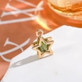 Macro view of a 14K gold-filled star pendant with a green zircon gem on a white stone - Star - Olive Green