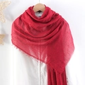Detail of red crinkle cotton linen scarf with frayed edges hanging on wooden hanger - Red