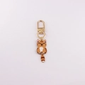 Close-up of golden cat keychain with orange enamel tabby design and movable tail - Orange Tabby Cat