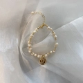 Detail of freshwater pearl bracelet with irregular pearls and a golden queen coin charm - 11# Woven Pearl Bracelet
