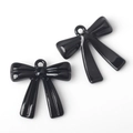Detail of two glossy black alloy bow charms with small rings for DIY jewelry making - Black